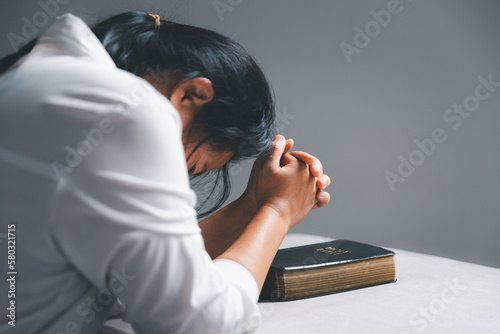woman kneeling and praying in modern house at sunset time. Female catholic prayer worship to God wish a better life in home at dawn with believe faith. concept of worshipers kneeling.