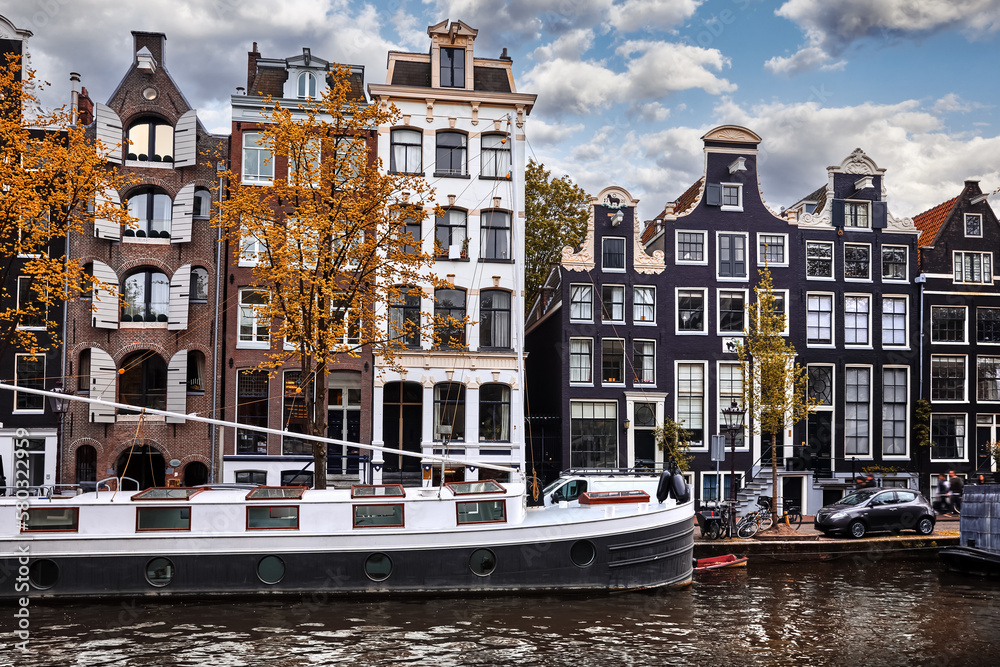 Amsterdam, Holland, Netherlands. Houseboat along the street with dancing houses on a canal. Big house boat water