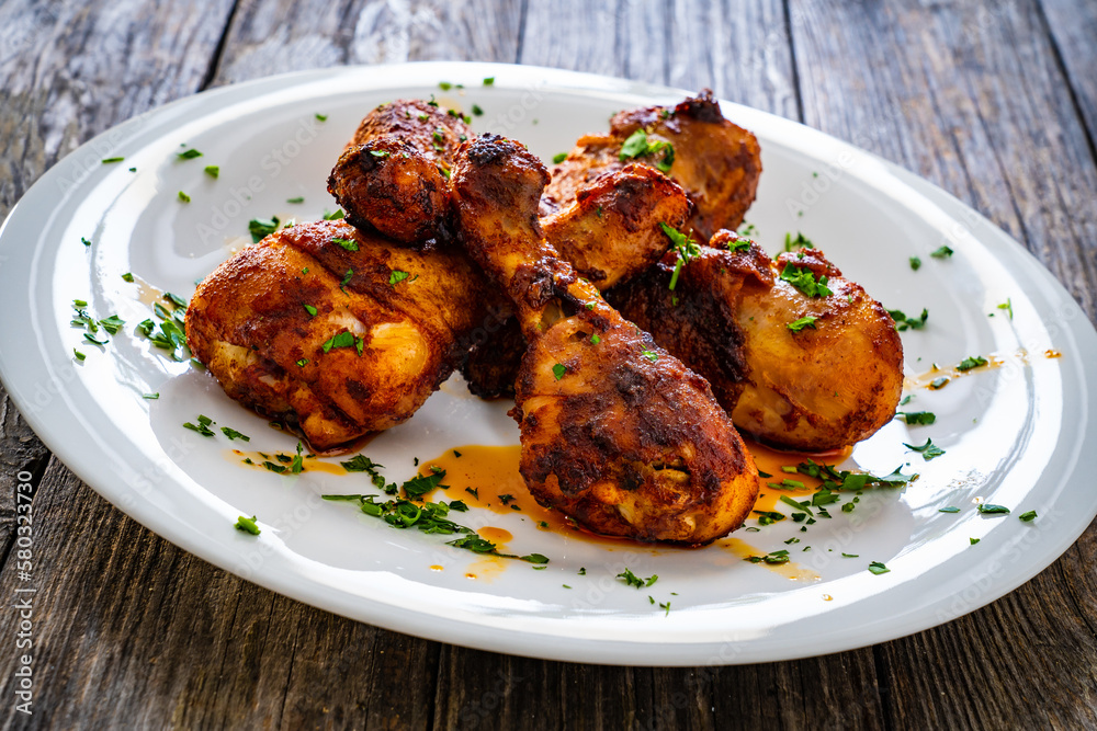 Barbecue chicken drumsticks with French fries on wooden table
Barbecue chicken drumsticks with French fries on wooden table
