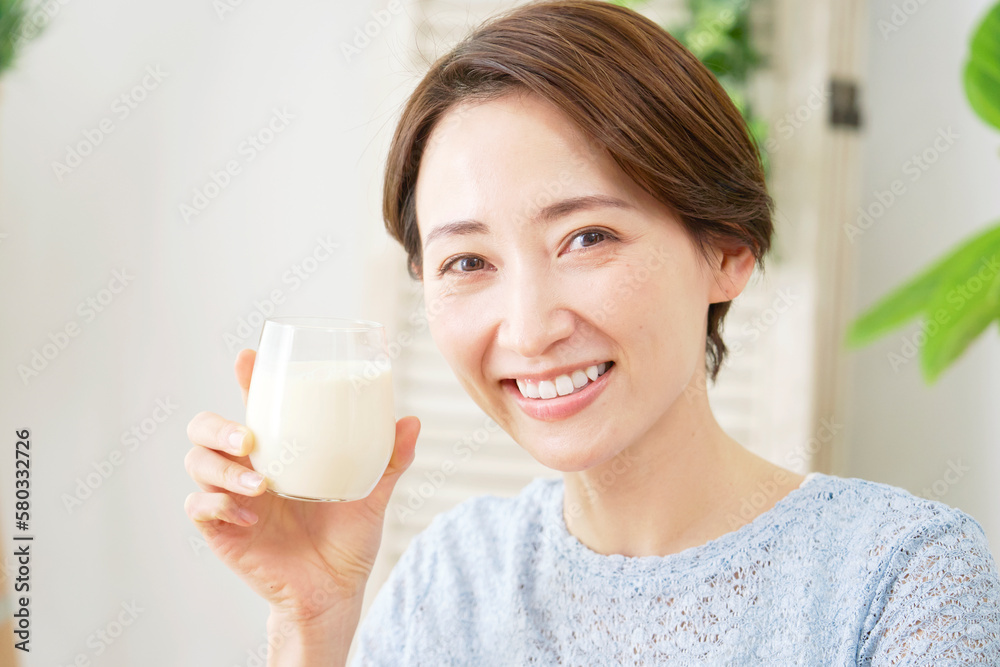 家で豆乳を飲む女性　カメラ目線