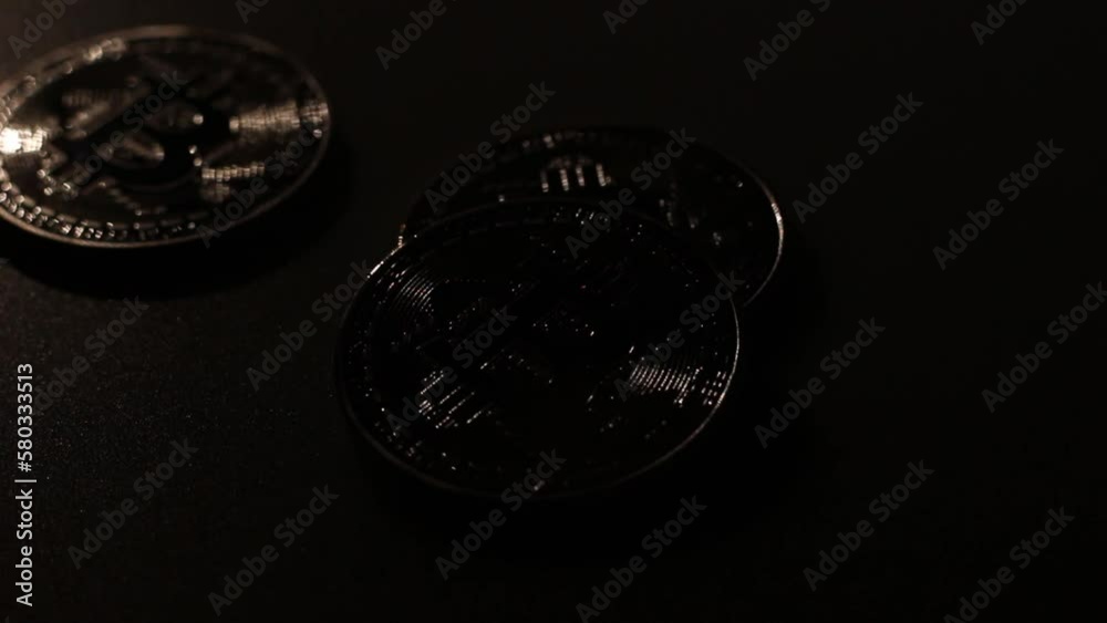 Light a flashlight on the bitcoins in the dark on the table. Light a flashlight on the bitcoins in the dark on the table.