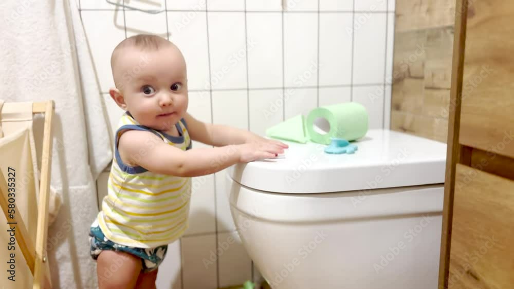 baby infant plays indulges in the toilet WC. learning and development kid dream family concept. funny adventures of the baby in the toilet WC. kid baby playing and studying in the bathroom lifestyle baby infant plays indulges in the toilet WC. learning and development kid dream family concept. funny adventures of the baby in the toilet WC. kid baby playing and studying in the bathroom lifestyle