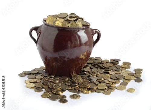 much of yellow metal coins in brown ceramic mug close up