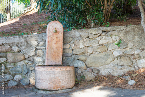 Historic red marble fountain in Moniga del Garda. The fountain was built on the wall of the castle in Moniga and still works today.