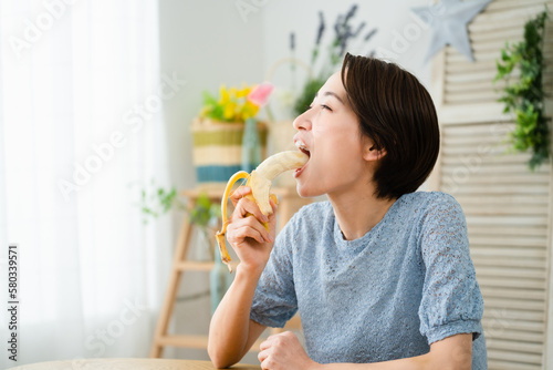 バナナを食べる若い女性 飲食イメージ