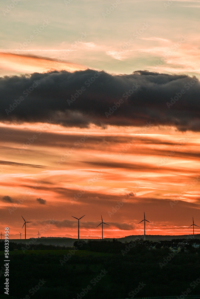 Wunderschöner Sonnenuntergang am Himmel mit goldenen Wolken und Windräder, Würburg, Franken, Bayern, Deutschland