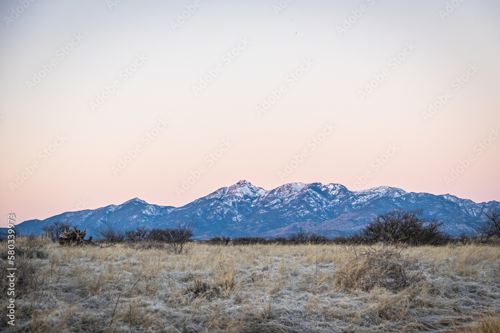 Distant mountain range with hills covered in grass in the forground in Arizona. Distant mountain range with hills covered in grass in the forground in Arizona.