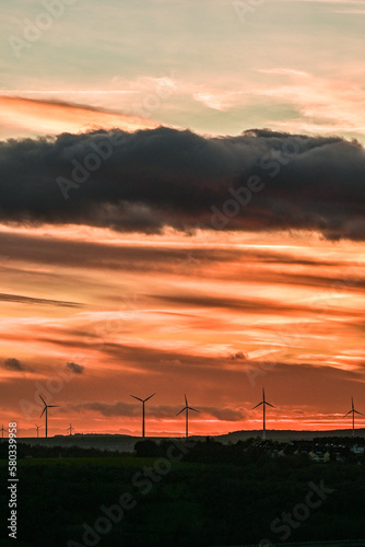 Wunderschöner Sonnenuntergang am Himmel mit goldenen Wolken und Windräder, Würburg, Franken, Bayern, Deutschland
