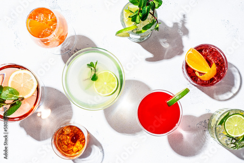Most popular cocktails set: aperol spritz, negroni, mojito, gin tonic and cosmopolitan, daiquiri, margarita and old fashioned on white background, top view. Hard light