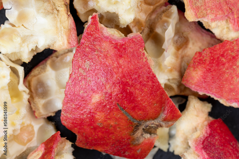 the peel of a red ripe pomegranate on a black board the peel of a red ripe pomegranate on a black board