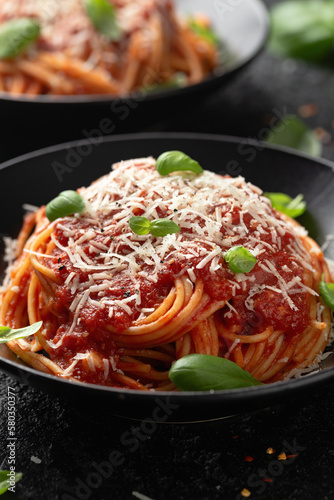 Italian marinara sauce spaghetti pasta served with fresh basil, olives and pecorino cheese