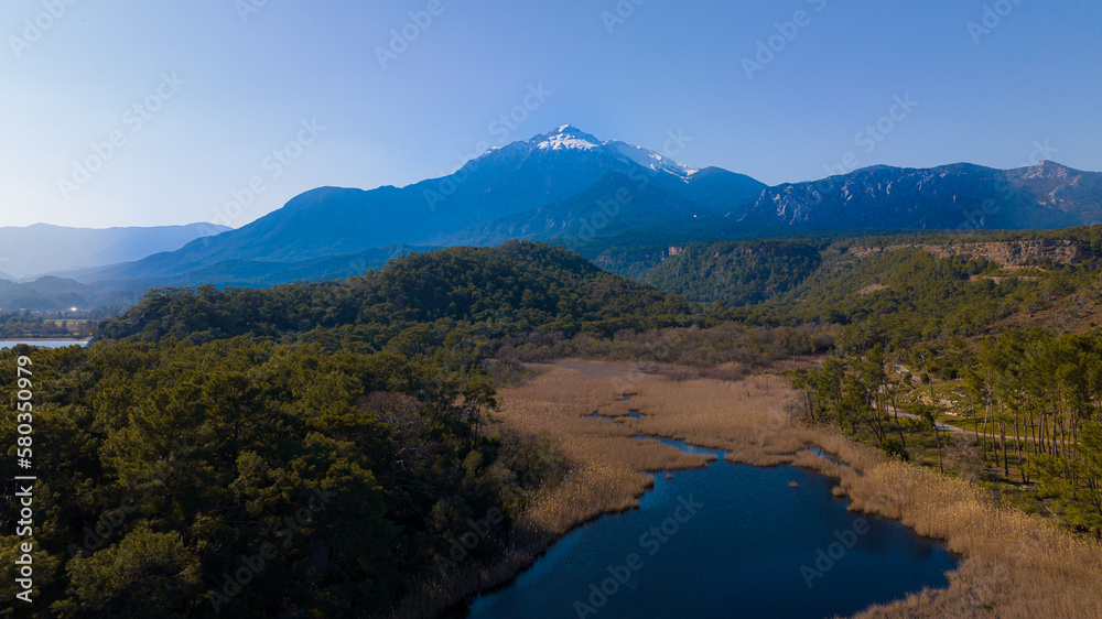 mountain landscape. Mountain lake and forest landscape. Mountain among the trees and snow on the mountain peak