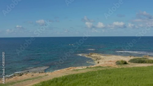 drone flies on a green field by the sea