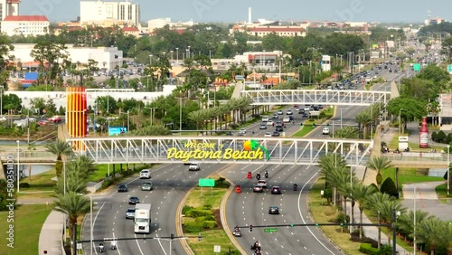 Welcome to Daytona Beach on a pedestrian overpass. 4k aerial drone video