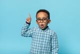 Great idea. Emotional black boy in eyeglasses pointing finger up and looking at camera, posing over blue background