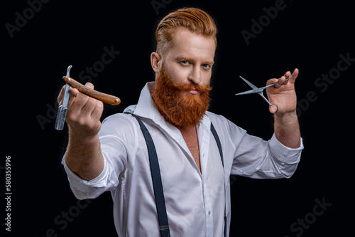 caucasian barber man in studio. barber man with scissors and retro razor blade.