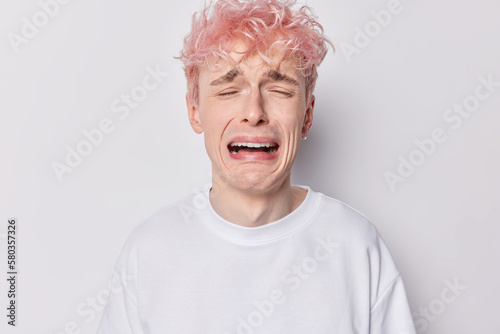Canvastavla Gloomy upset man with pink hair cries from despair complains about bad life whines desperately feels down depressed wears casual t shirt isolated over white background