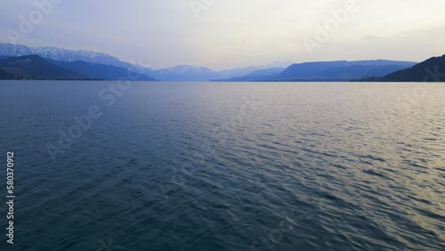 Beautiful low altitude drone view of Lake Attersee, Upper Austria, Europe, on a dark, cloudy, cold early spring day - camera moves forward fast, then ascending