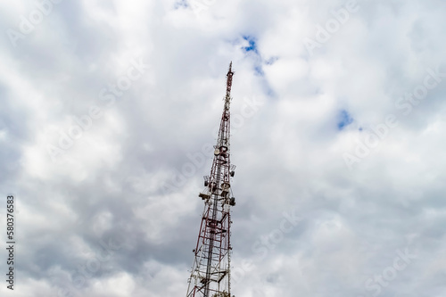 Communication tower against a cloudy gloomy sky