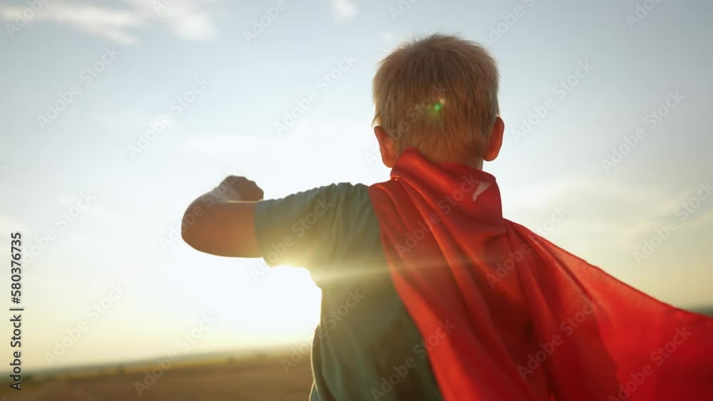 kid superhero. boy happy family a dream concept. baby boy superhero close-up in red cape at sunset. portrait child superhero close-up from the back. strength lifestyle fantasy concept kid superhero. boy happy family a dream concept. baby boy superhero close-up in red cape at sunset. portrait child superhero close-up from the back. strength lifestyle fantasy concept