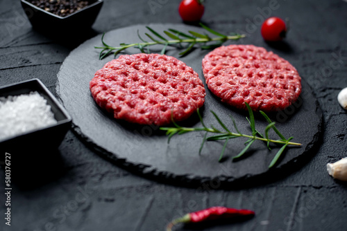 raw beef cutlets for burgers on stone background