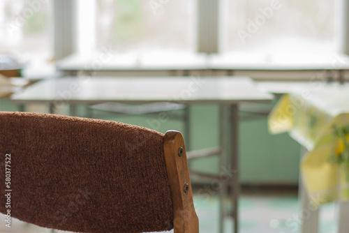 Chairs, a window and a table in an abandoned and dilapidated holiday house in the style of the People's Republic of Poland. Day. photo