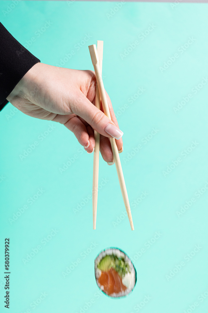 Savoring Delicious Sushi Between Chopsticks Savoring Delicious Sushi Between Chopsticks