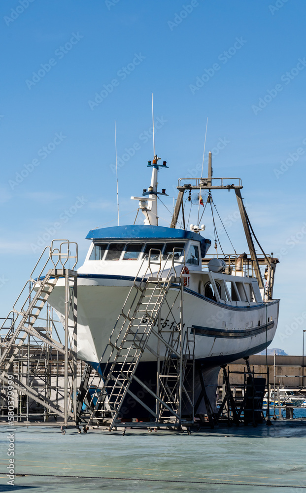 A fishing boat being repaired in the shipyard.