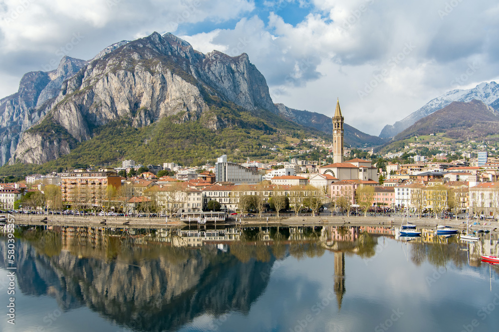 Fototapeta premium Sunny aerial cityscape of Lecco town on spring day. Picturesque waterfront of Lecco town located between famous Lake Como and scenic Bergamo Alps mountains.