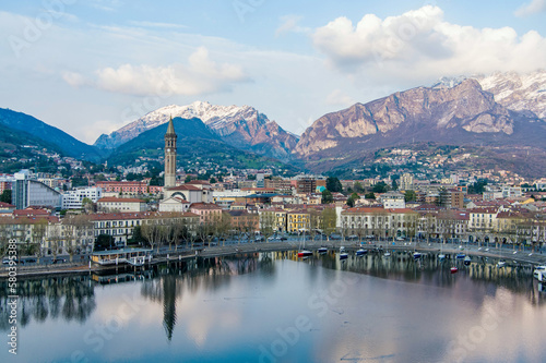 Cloudy aerial cityscape of Lecco town on spring evening. Picturesque waterfront of Lecco town located between famous Lake Como and scenic Bergamo Alps mountains.