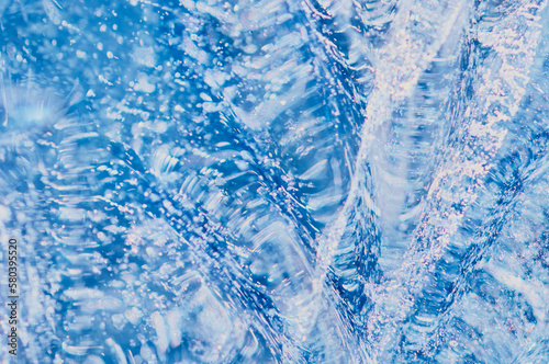 Abstract texture background of pure natural ice. Selective focus. Wave and curvature of space.