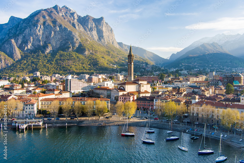 Sunny aerial cityscape of Lecco town on spring morning. Picturesque waterfront of Lecco town located between famous Lake Como and scenic Bergamo Alps mountains.