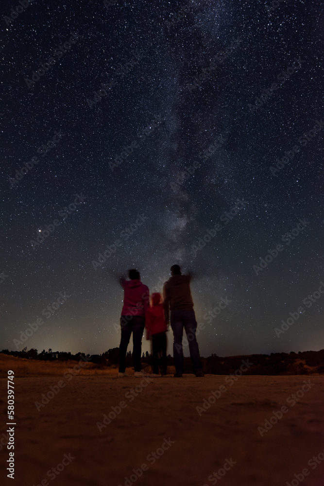 Parents with their daughter watching the milky way