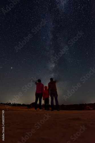 Parents with their daughter watching the milky way
