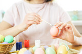 Portrait of young pretty woman painting Easter eggs. Happy easter. Close-up. Copy space.