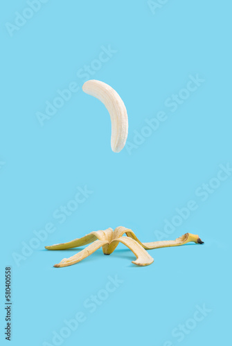 Flying peeled banana on the pastel blue background.