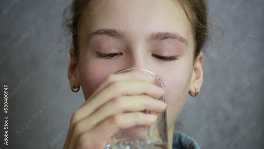 Young girl sipping water from glass. Slow motion Young girl sipping water from glass. Slow motion