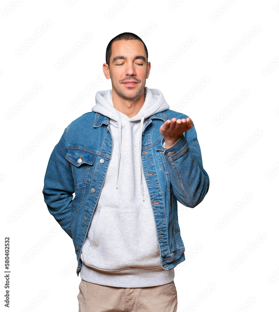 Happy young man holding something with his hand Happy young man holding something with his hand
