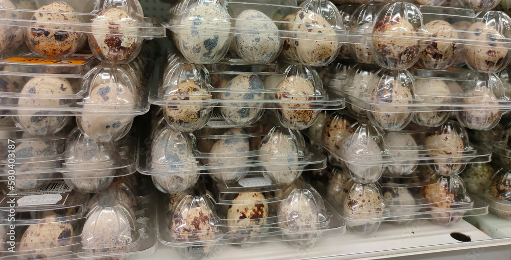 quail eggs in disposable transparent plastic containers on a shelf in a supermarket