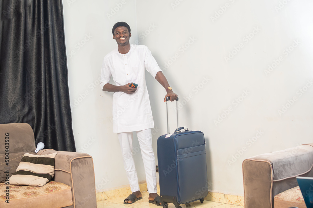 Full length of smiling young traveler tourist man using mobile phone booking hotel taxi