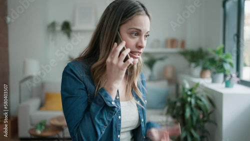 Video of angry beautiful woman talking on the phone at home.