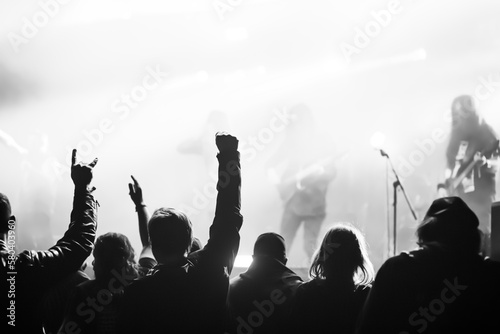 Crowd at concert with hands raised in the air, blurred background