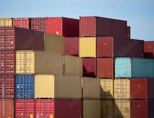 Stacks of large iron cargo containers for transporting import and export of various goods by sea vessels in industrial port, sea freight trade international transportation, logistics concept.