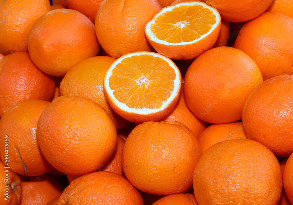 background of ripe orange oranges and some cut in half for sale in the greengrocer background of ripe orange oranges and some cut in half for sale in the greengrocer