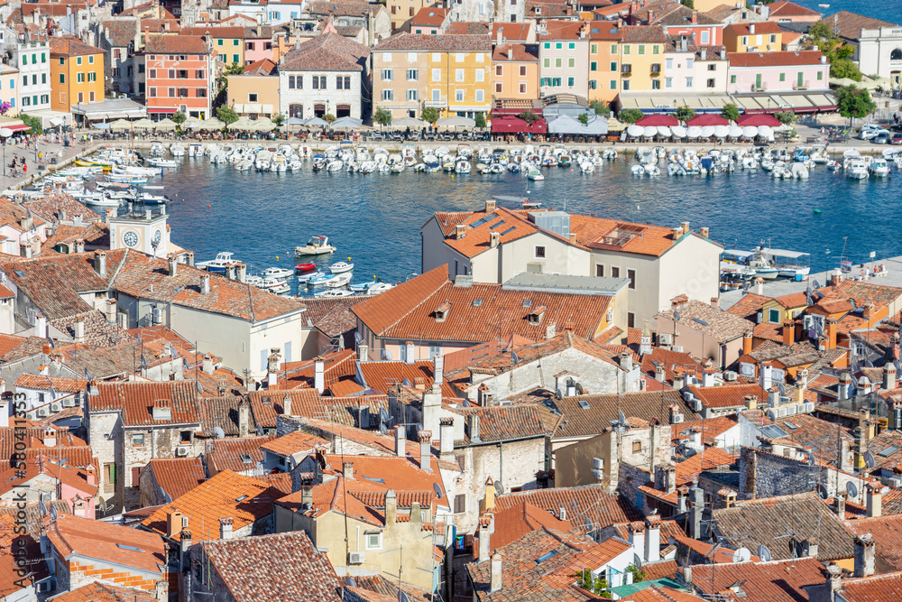 Old houses and roofs with port and boats from above in Rovinj old town, Croatia
