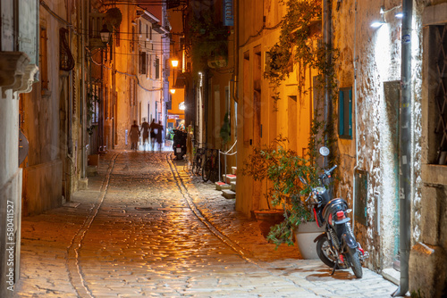 Cobbled street with old houses details by night in Rovinj old town, Croatia
