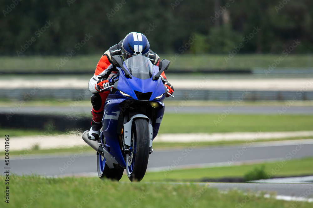 Motorcycle rider riding at high speed on his blue sport motorcycle. Motorcycle rider riding at high speed on his blue sport motorcycle.