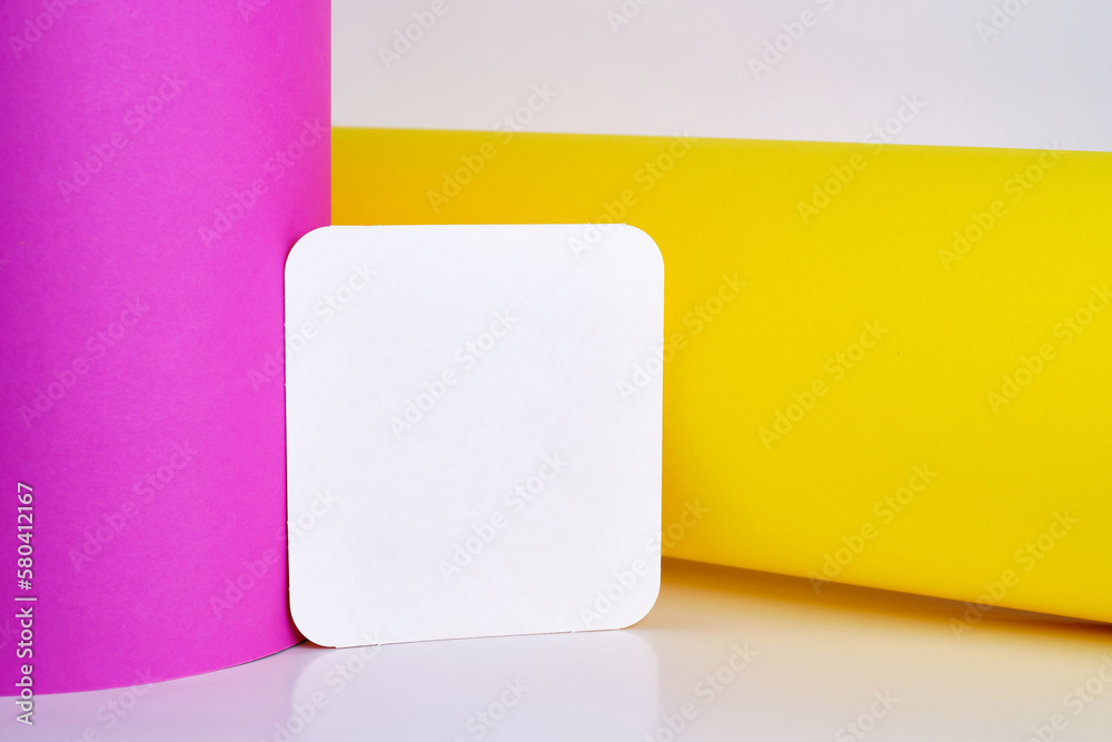 Fototapeta premium Blank white card isolated on pink and yellow background. Place for text. Mock up greeting card. Form 