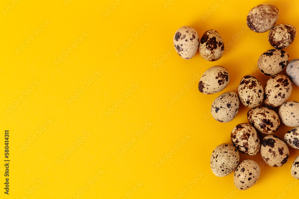 Quail eggs lays on yellow paper background with copy space or empty place for text. Easter holiday. Visiting card. Religious layout. Springtime design. Healthy food product. Farm organic production