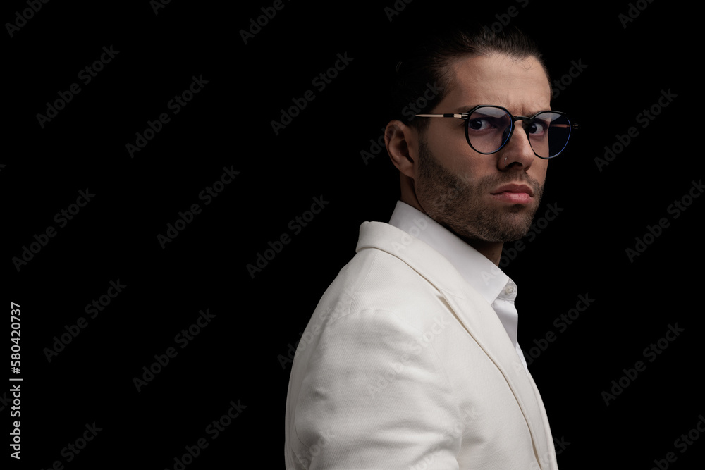Obraz premium side view of cool elegant man with glasses wearing white suit